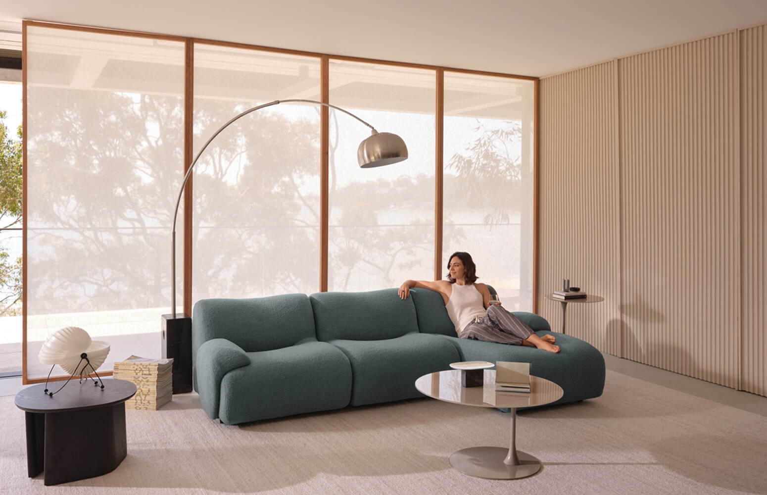 A woman relaxes on a blue sofa in a contemporary living room.