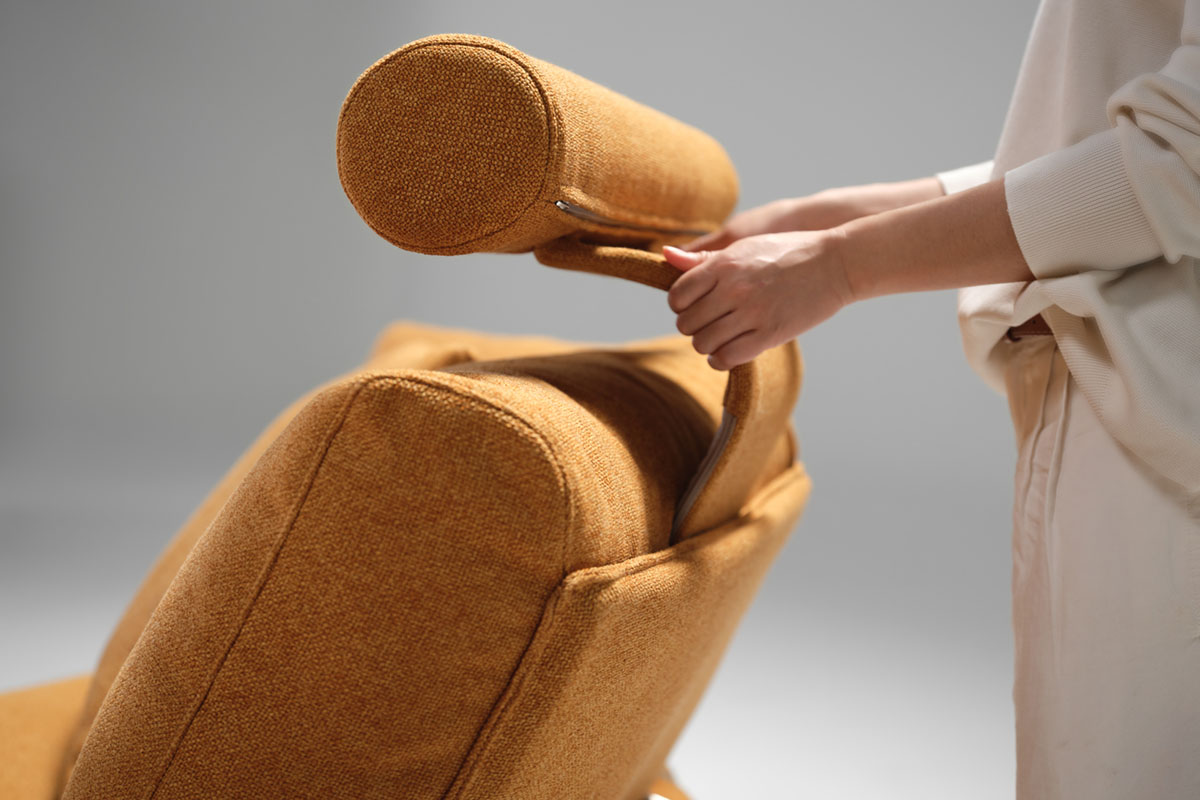 Close-ups of Delta 5 Sofa in a soft orange fabric showcasing the curved headrest and integrated accessories like charging table.
