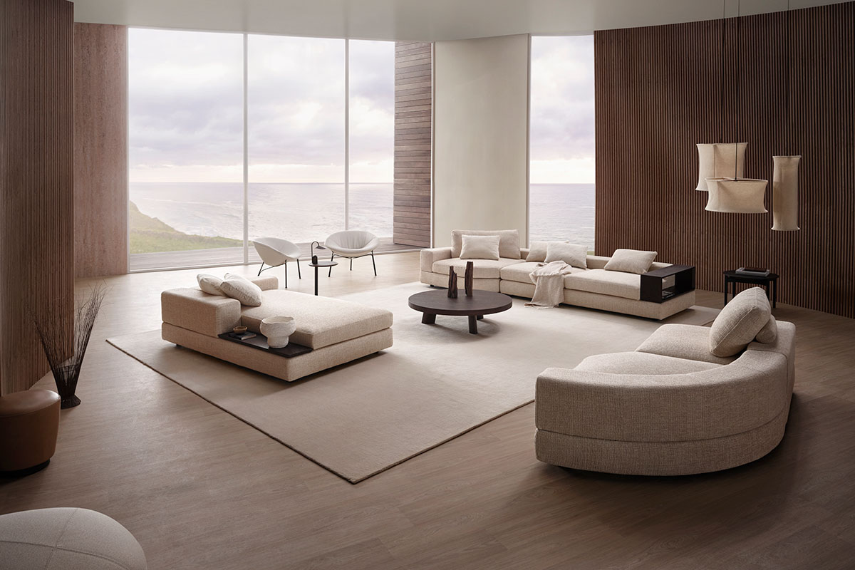 Jasper modular sofa in a natural fabric, configured with curved modules across an open-plan living space.