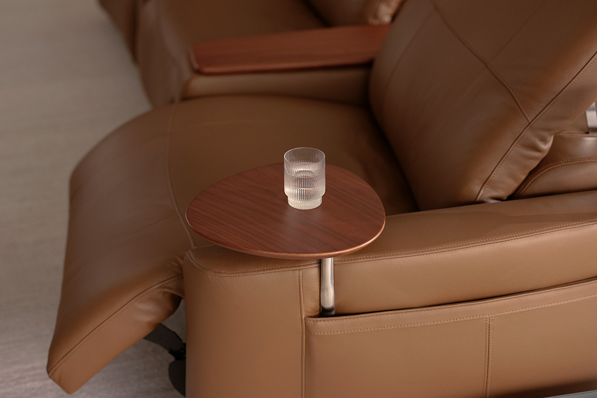 Modern reclining sofa in a chocolate brown tan leather styled with smart accessories for a cinema experience.