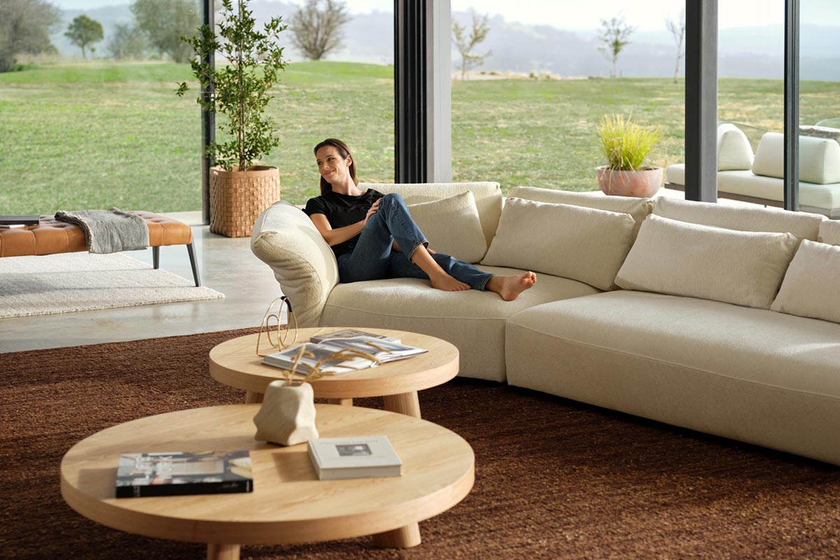 Organic modern living room with a modular sofa and wood coffee tables, styled in a warm earthy palette.