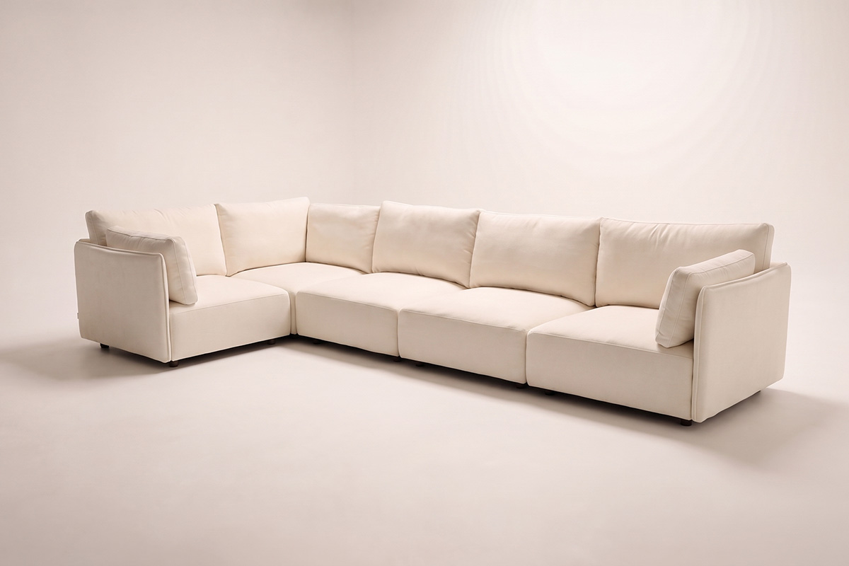 Modular sofa from 2010 is styled in a studio room. It is L-shape and recovered in a new white fabric.