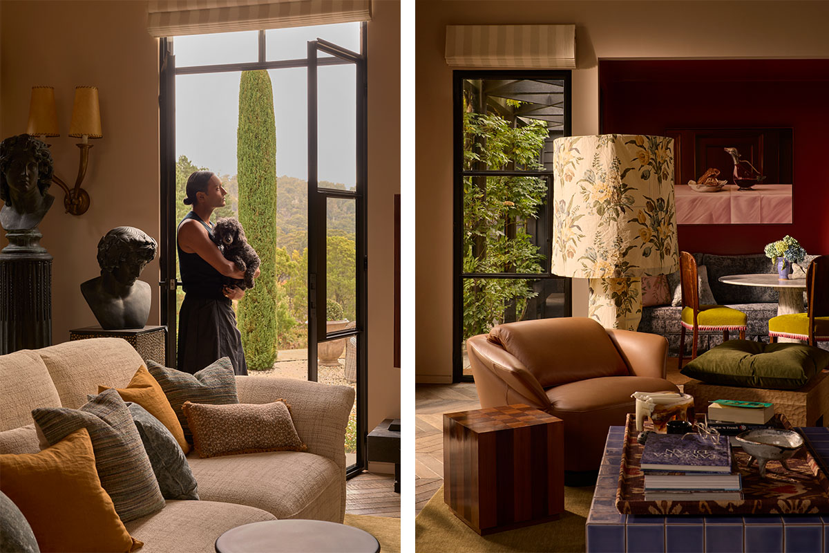 Brahman holds dog by open door, with modular sofa, leather armchair and floral lamp in a layered and eclectic, warm-toned interior.