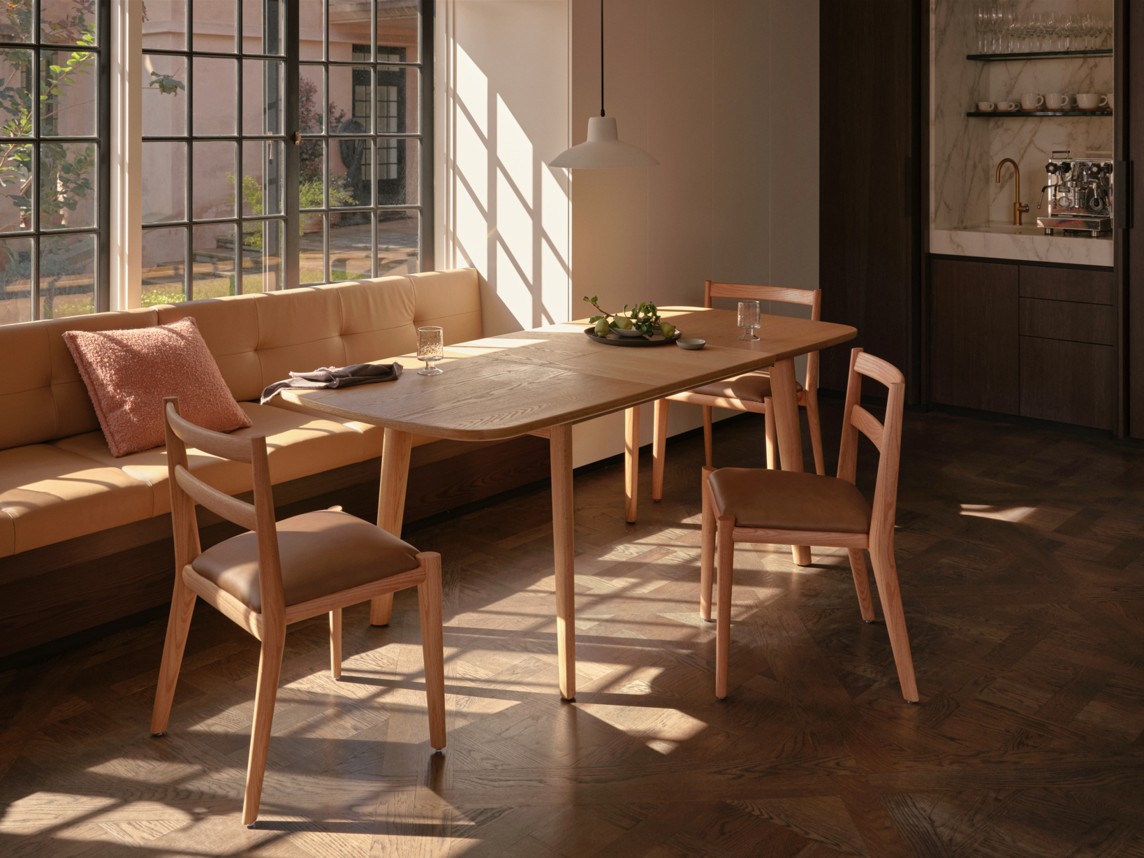 Natural oak dining setting in a small dining room, sunlit and contemporary with blush pink décor.