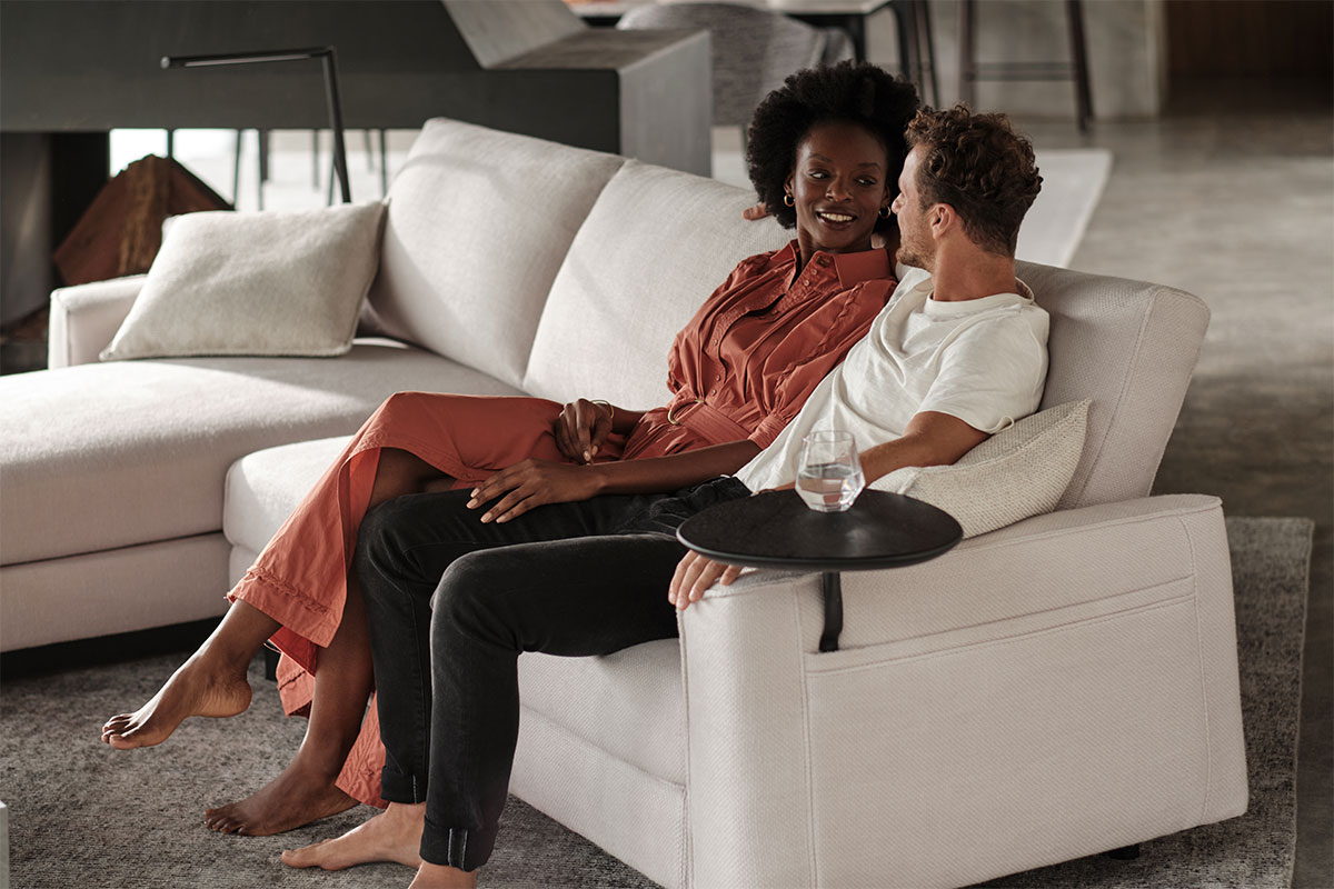 A couple relax on a timeless white modern sofa.