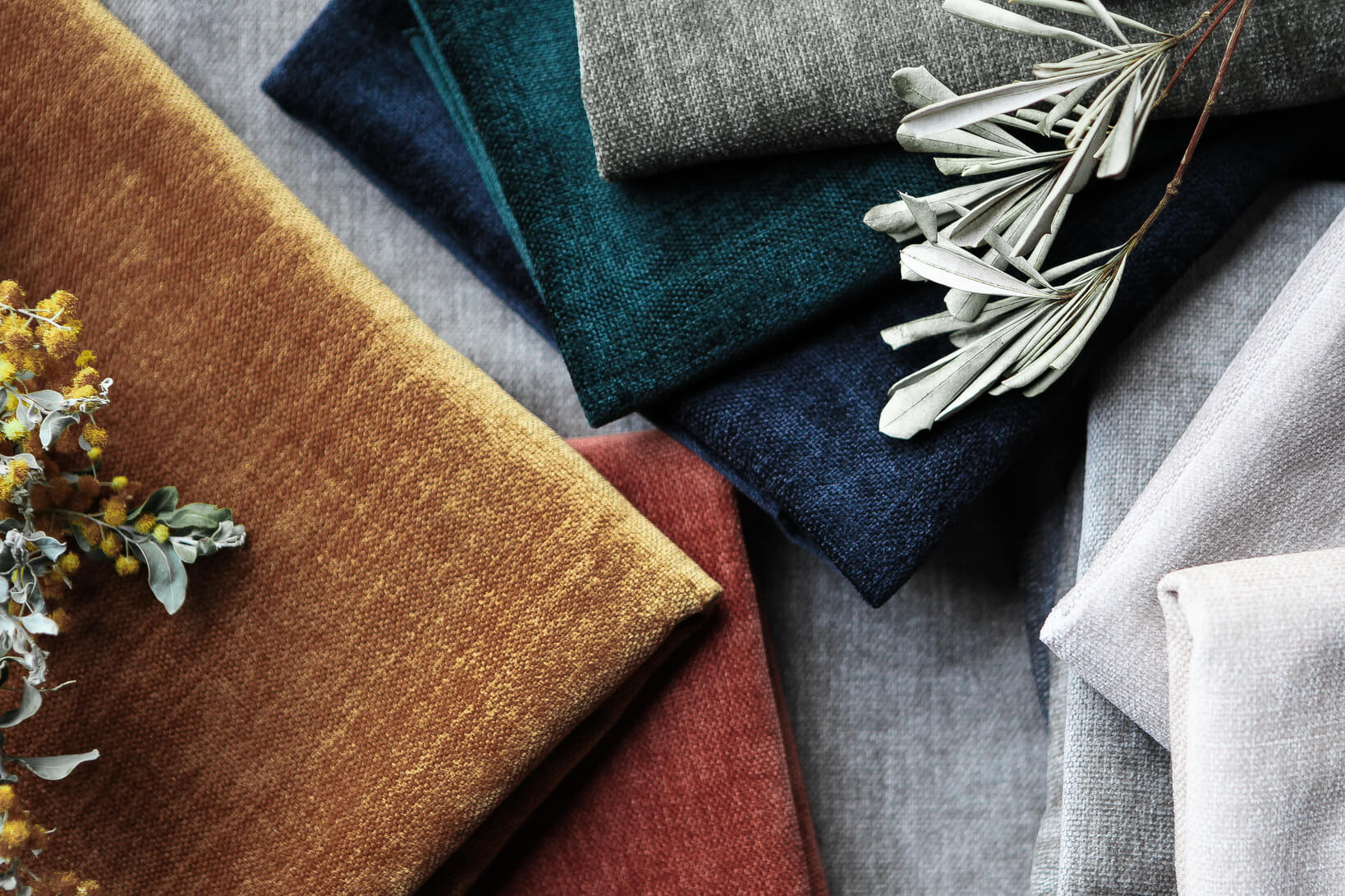 A flat lay of soft chenille fabrics in rich earthy tones.