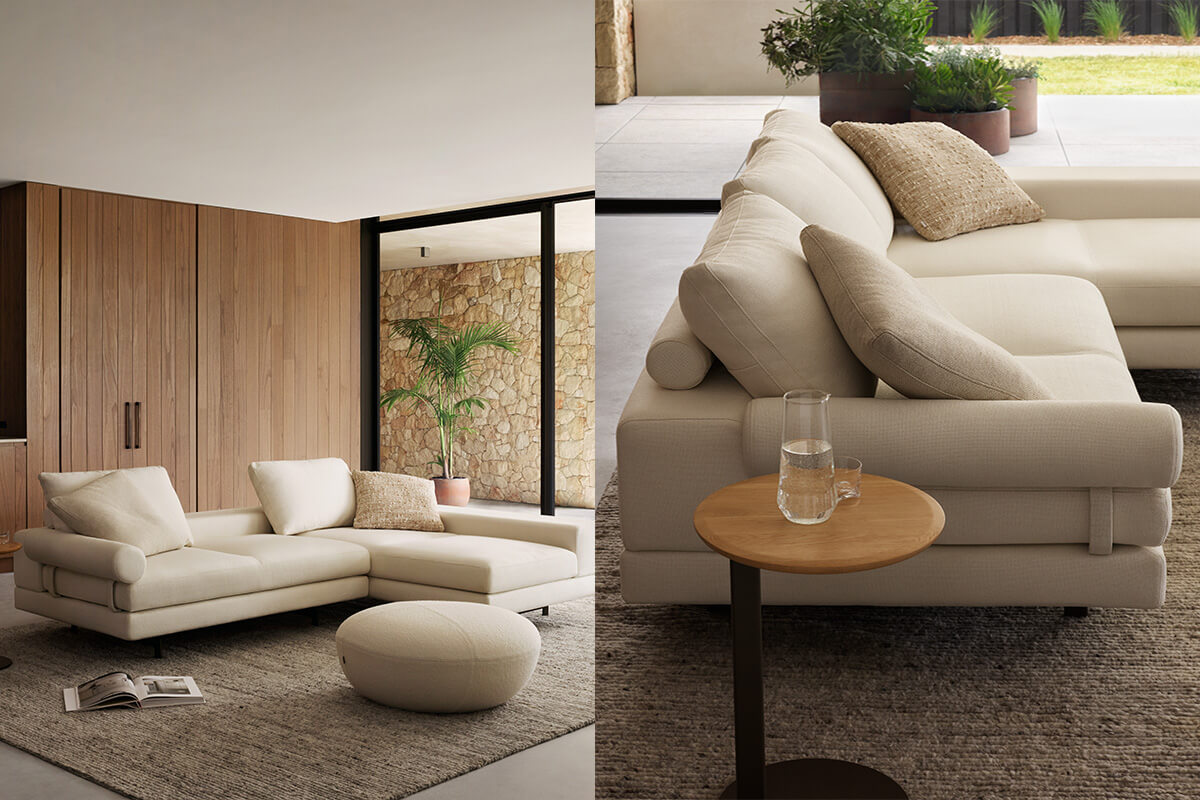 Contemporary L-shaped sofa with chaise in soft cream fabric styled with tonal cushions and a matching ottoman, set in a light-filled space.