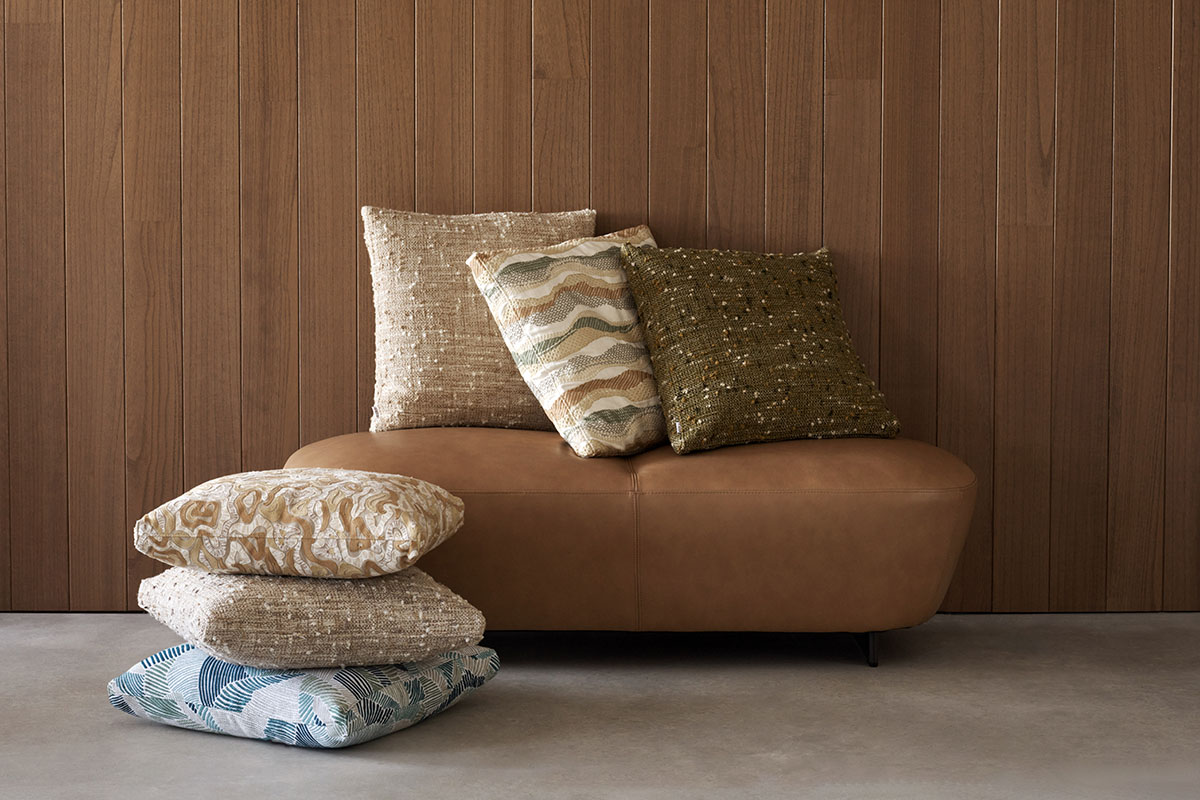 An earthy toned guest bedroom styled with layered linen bedding in blush hues and green accents.