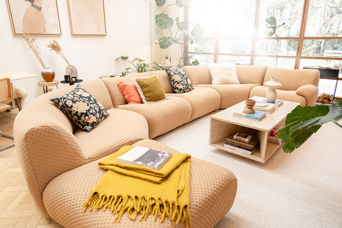 Modern, light-filled living space showcasing the 1977 Sofa with interchangeable seasonal covers, styled with warm textures and natural materials.