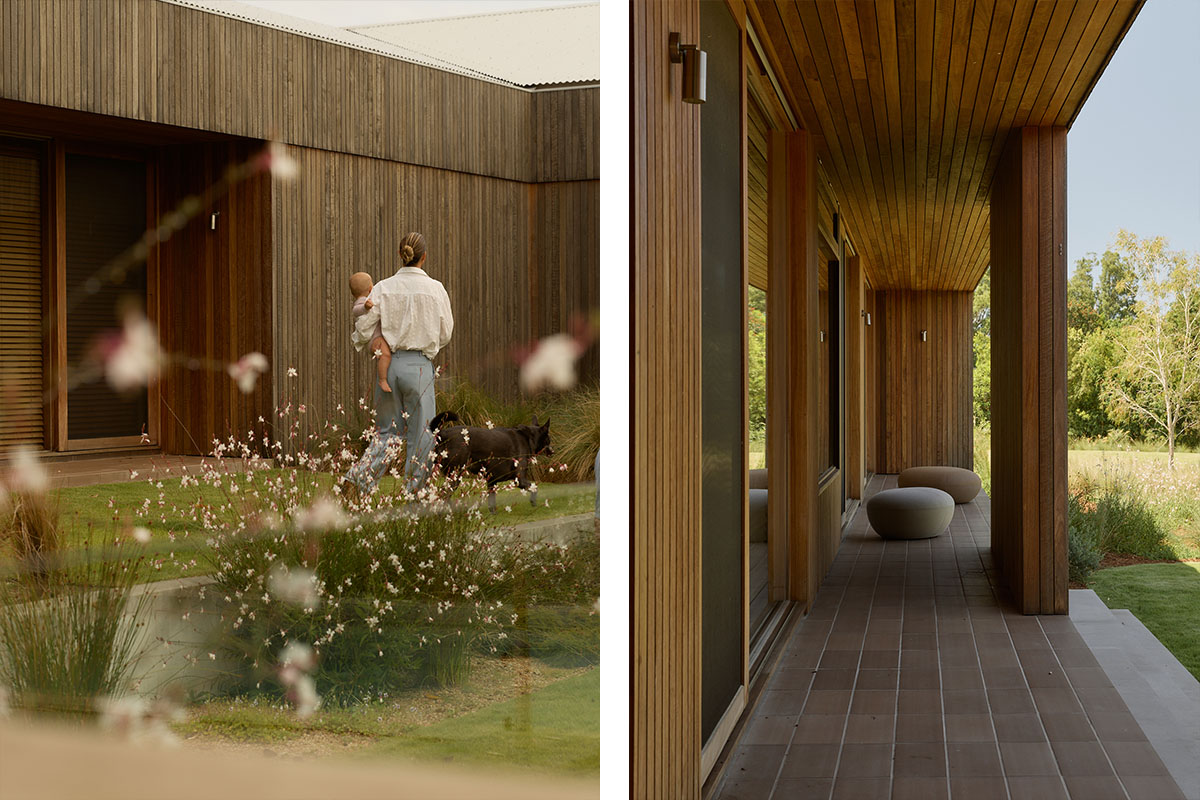 A woman carries a baby through the garden beside her dog, a timber veranda, and a native garden with an outdoor table and benches.