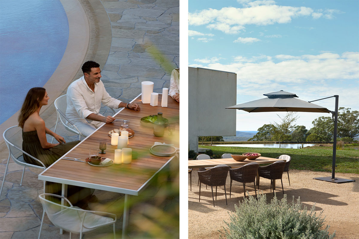 Guests sit at a rectangular teak outdoor table hosting a dinner party shaded by an outdoor umbrella.