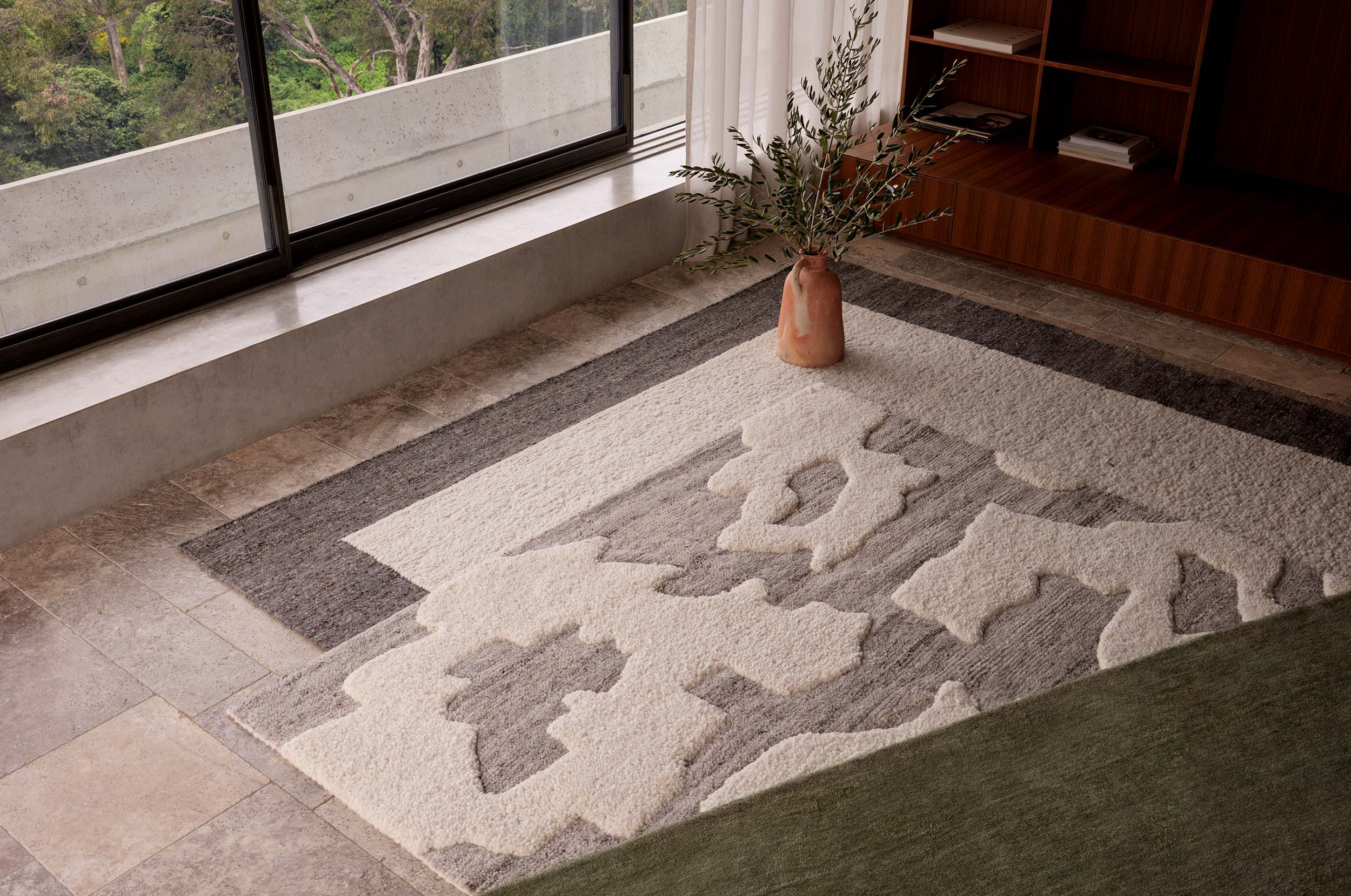 A layering of tonal King Living rugs in earthy hues, styled in a contemporary living space.