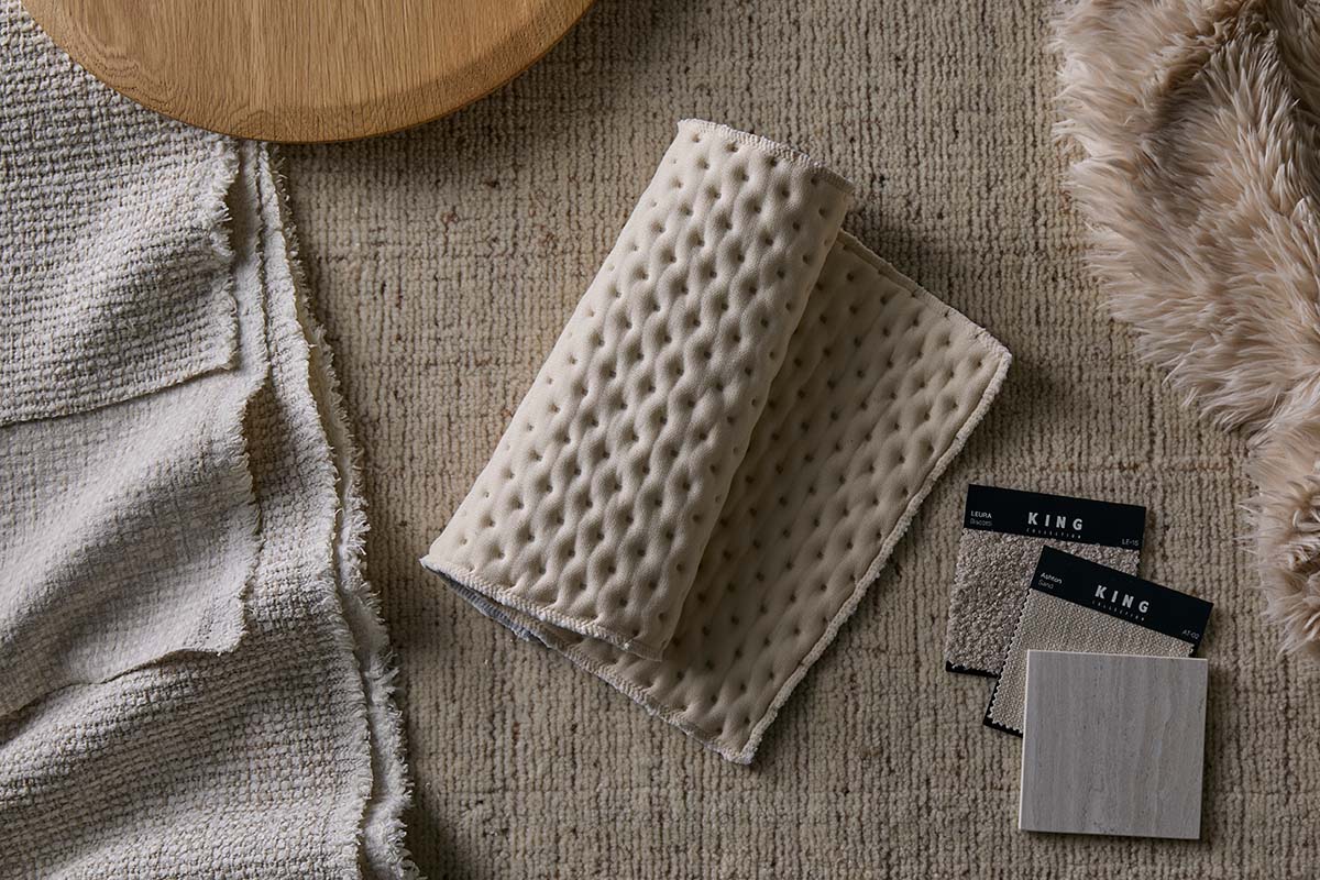 A flat lay showcasing a collection of different fabrics and textures in neutral tones.